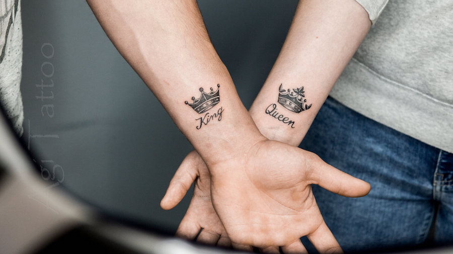 Narzeczeni prezentują tatuaże dla par na nadgarstkach przedstawiające koronę króla i królowej.